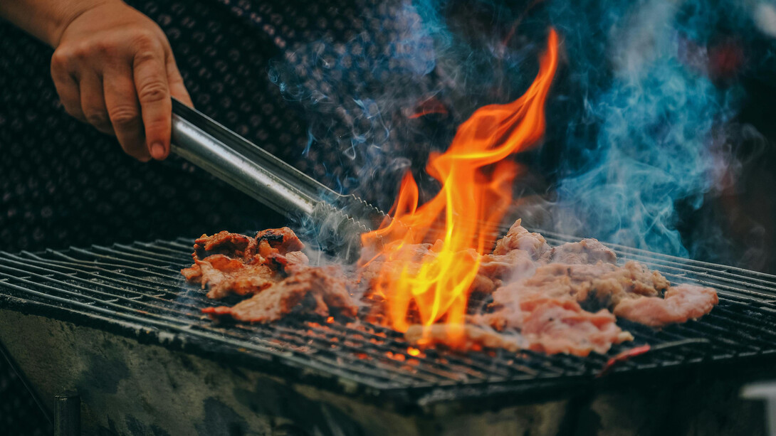 Grilling meat over charcoal flames