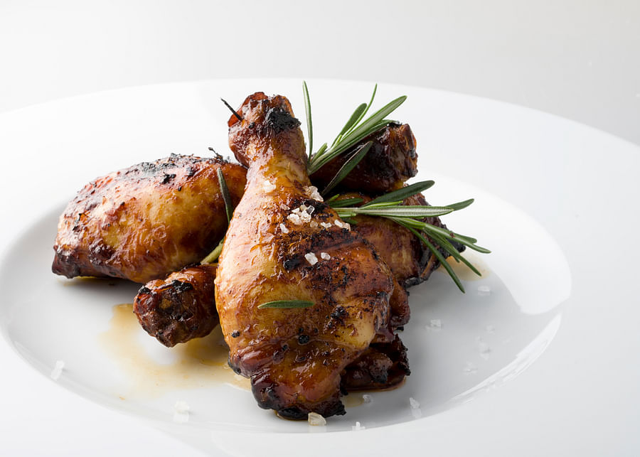 Delicious grilled chicken legs and drumsticks served on a plate, ready to eat