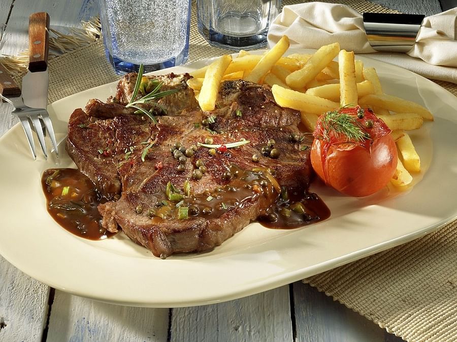 Succulent T-Bone steak freshly grilled and garnished on a plate