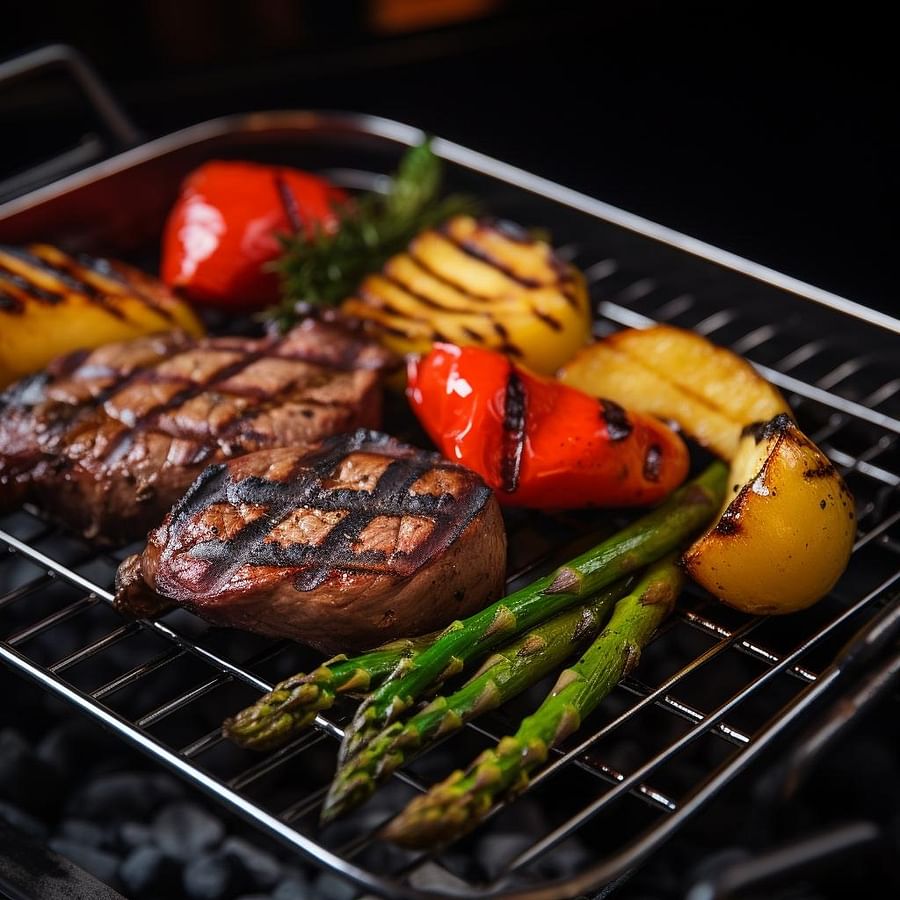 Grilled vegetables in a grill basket next to a filet mignon