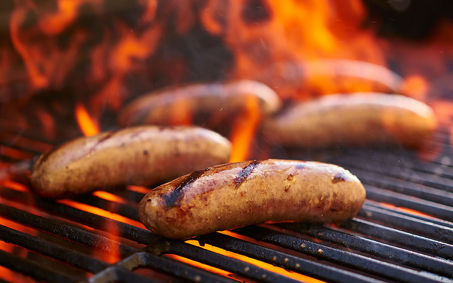 Sizzling Bratwurst Sausage Cooking on a Grill